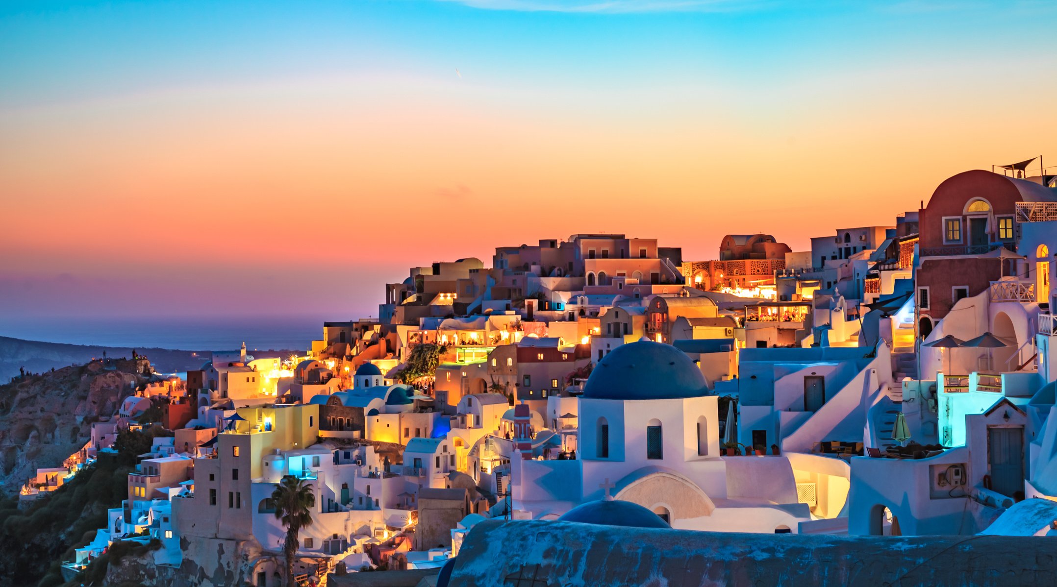 Sunset Panoramic view over Oia village in Santorini Greece, luxury travel vacation,